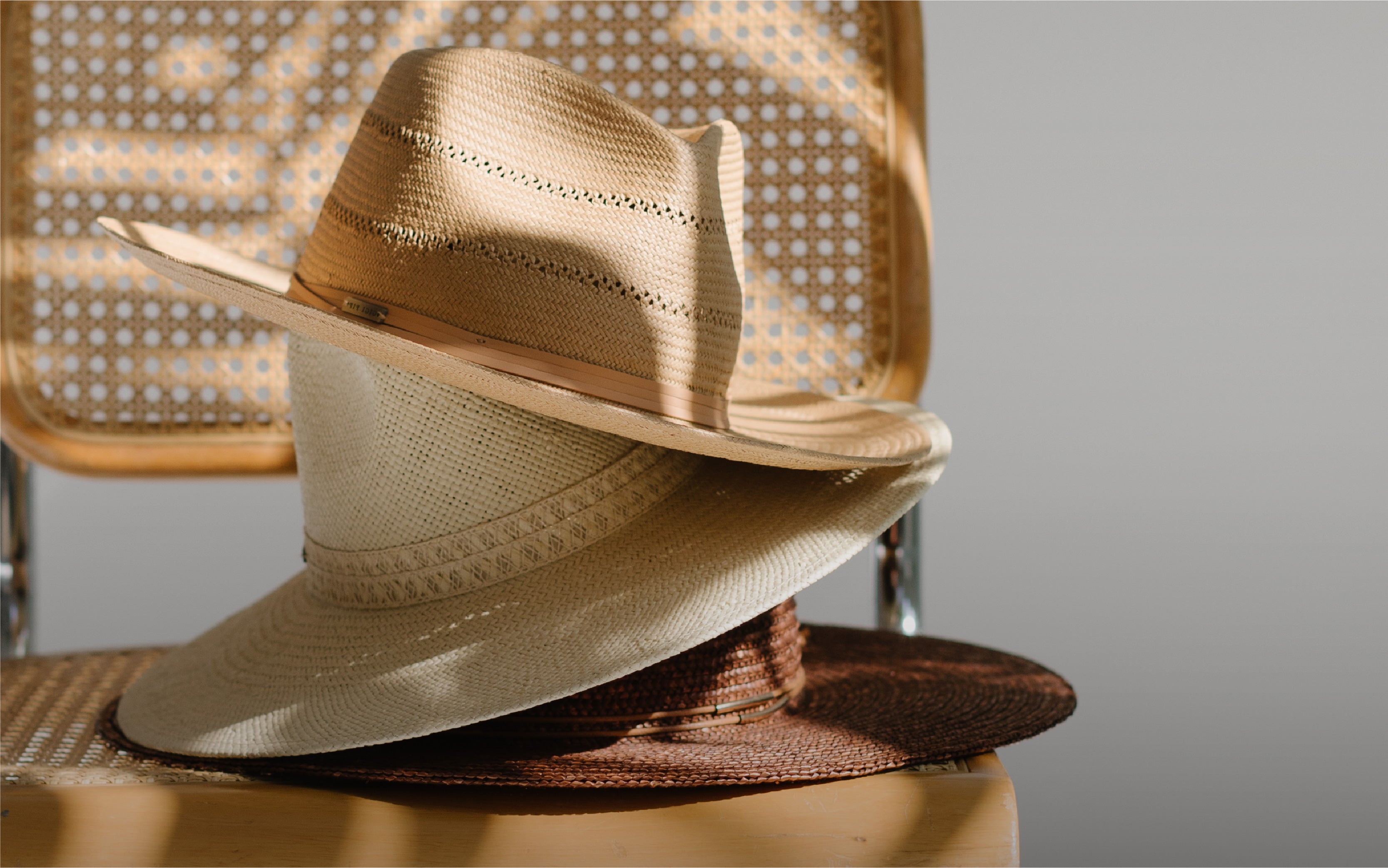 straw hats on a rattan chair