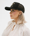 Gigi Pip trucker hats for women - Gigi Rodeo Foam Trucker Hat - 100% polyester foam + mesh trucker hat with a curved brim featuring the words "gigi rodeo" in a contrasting color as a design across the front panel [black]