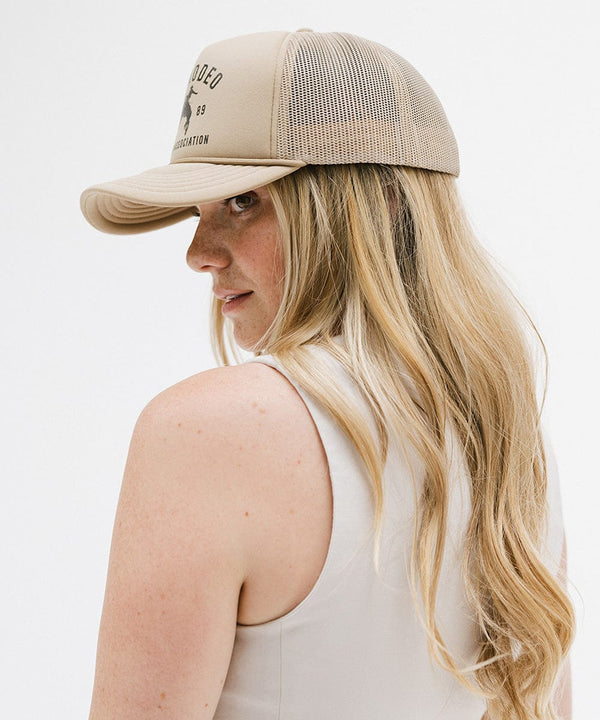 Gigi Pip trucker hats for women - Gigi Rodeo Foam Trucker Hat - 100% polyester foam + mesh trucker hat with a curved brim featuring the words "gigi rodeo" in a contrasting color as a design across the front panel [tan]